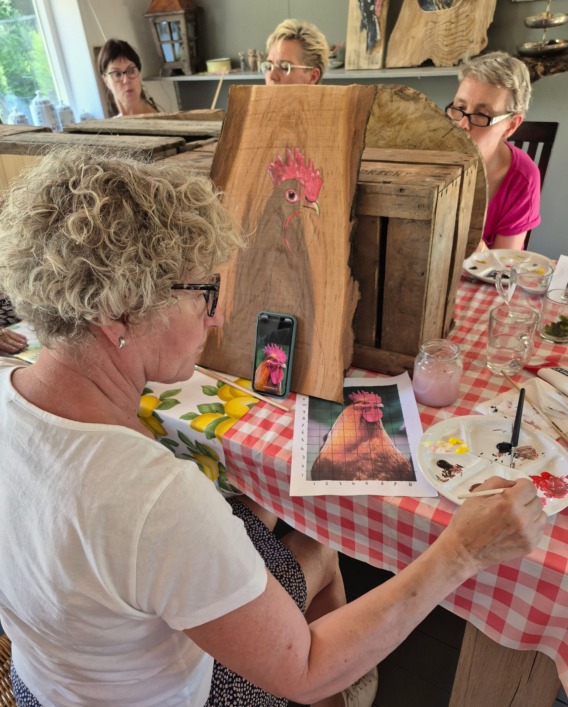 Deelnemer schildert een dier op Hoeksche Waards hout tijdens een creatieve schilderworkshop.