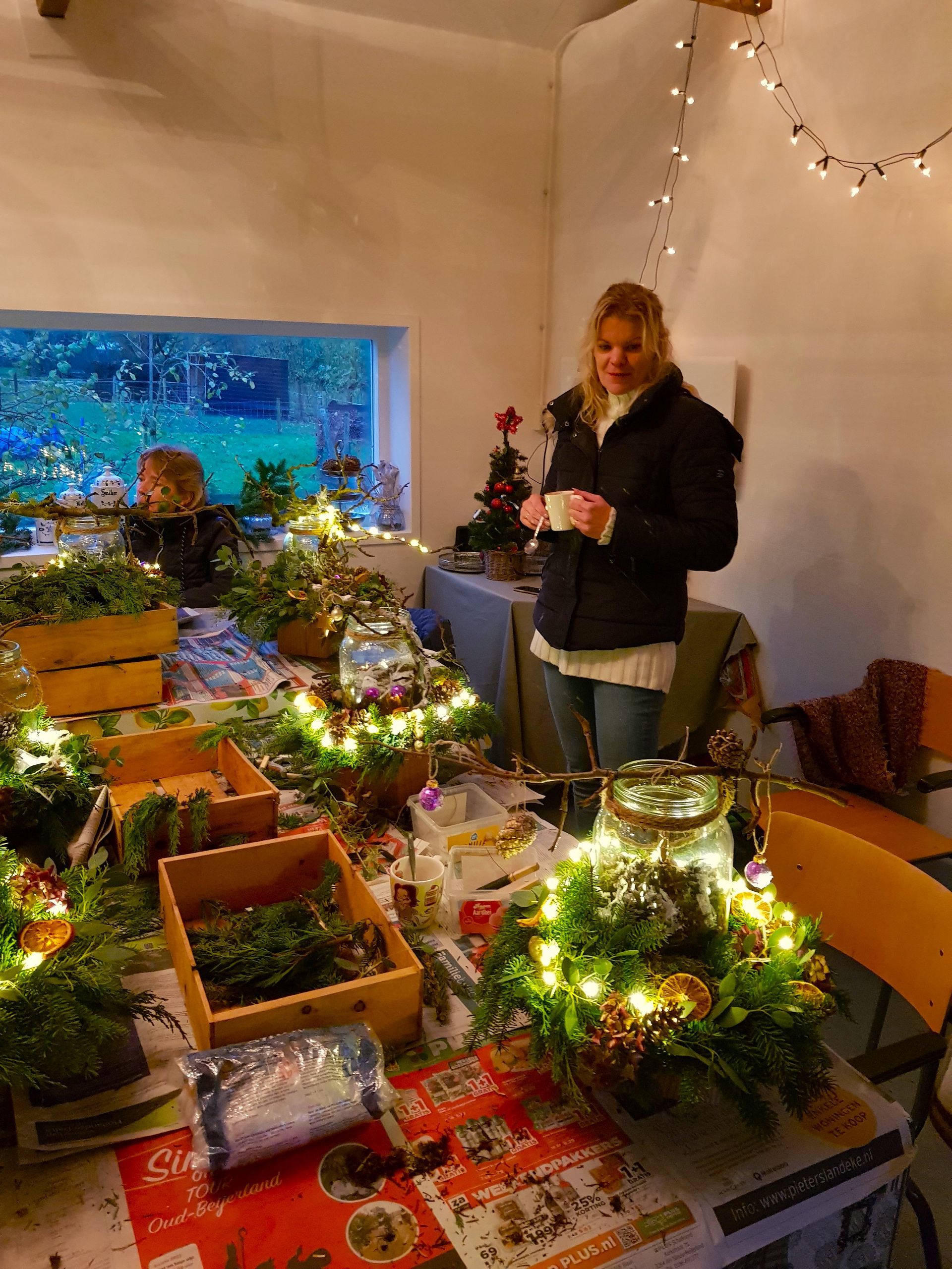 Bezoeker geniet van haar zelfgemaakte kerstdecoratie tijdens een creatieve seizoensworkshop.