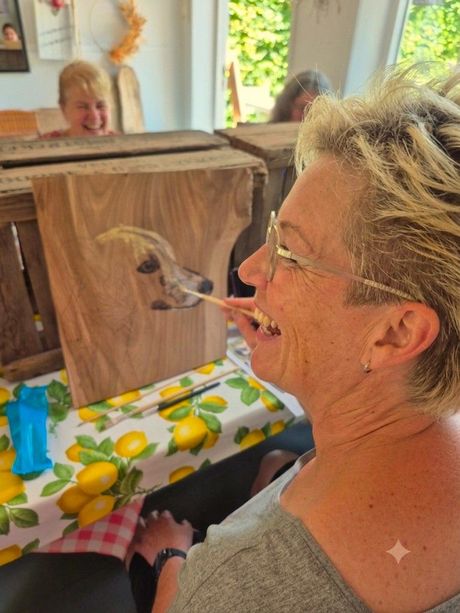 Deelnemer schildert een zelfgekozen dier op duurzaam Hoeksche Waards hout tijdens een creatieve workshop.