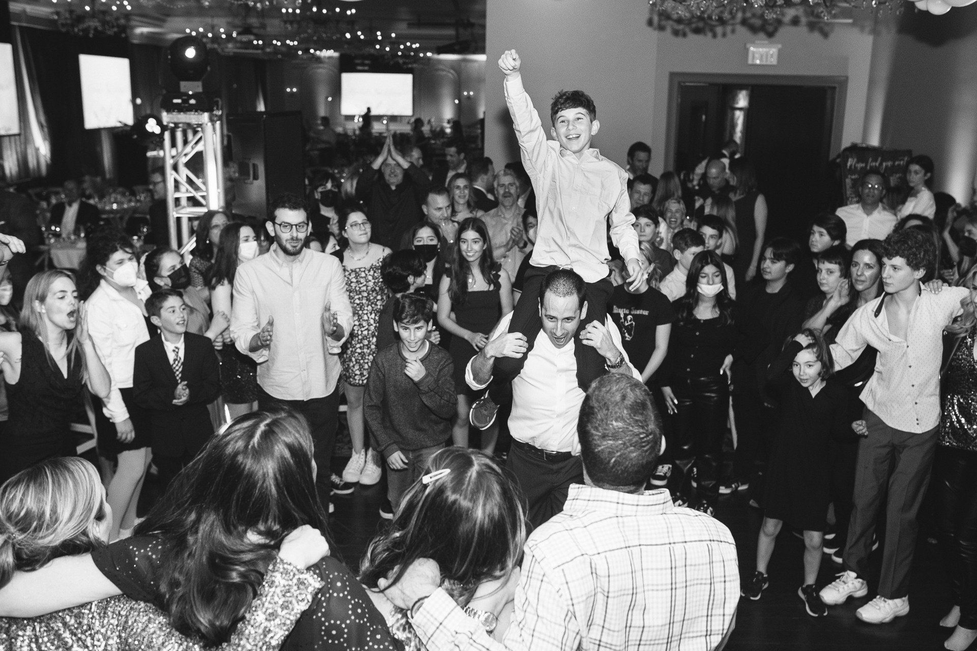 Happy child riding on his fathers shoulders at his bar mitzvah
