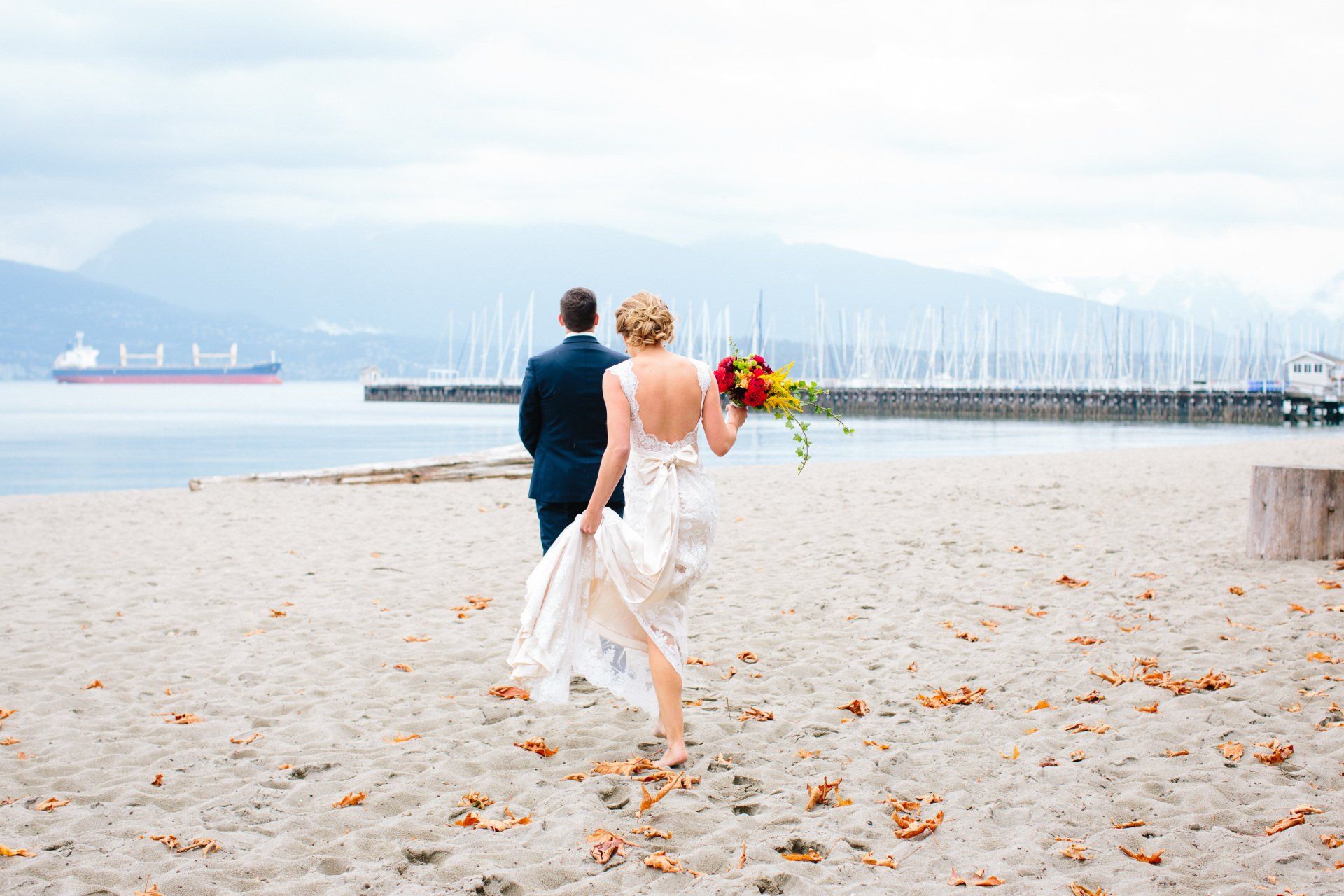 Bride and groom barefoot in the sand on the beach