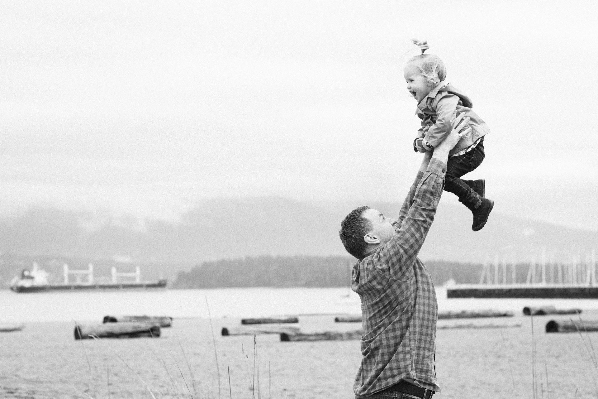 Family photo of a father hold his daughter up in the air