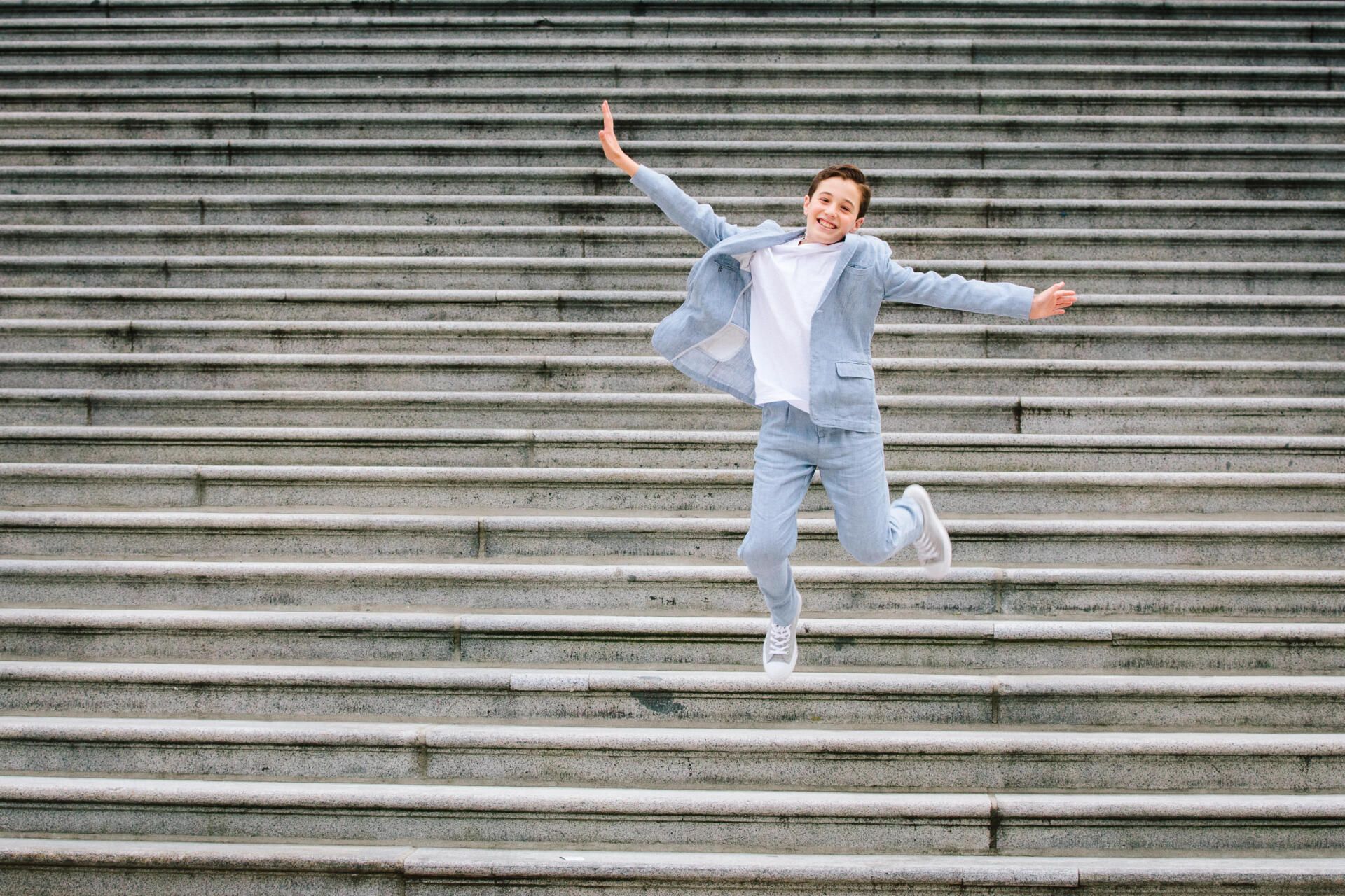 Small boy skipping down the stairs at a bar mitzvah event