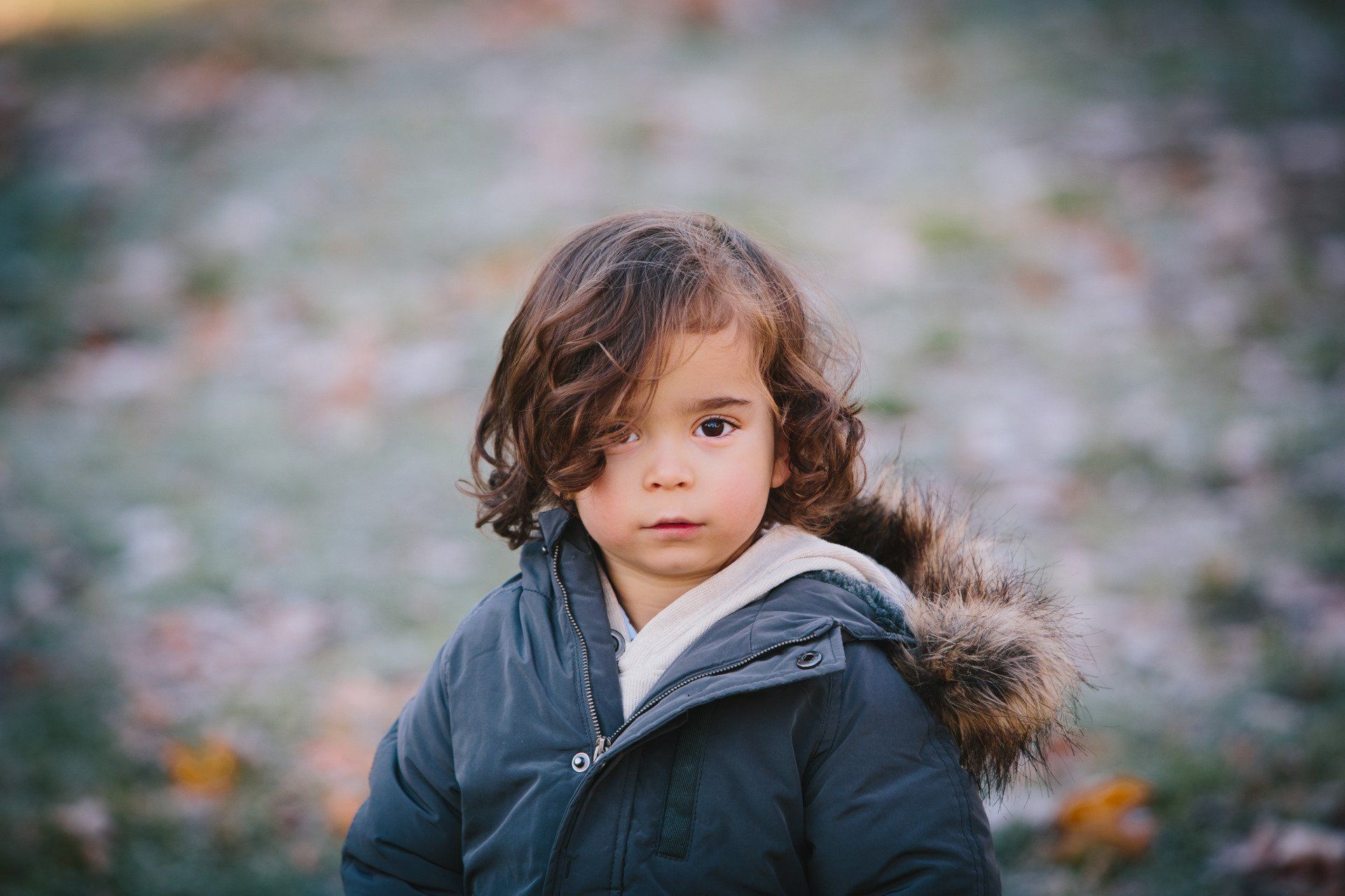 Portrait photo of a small girl wearing a parka in autumn