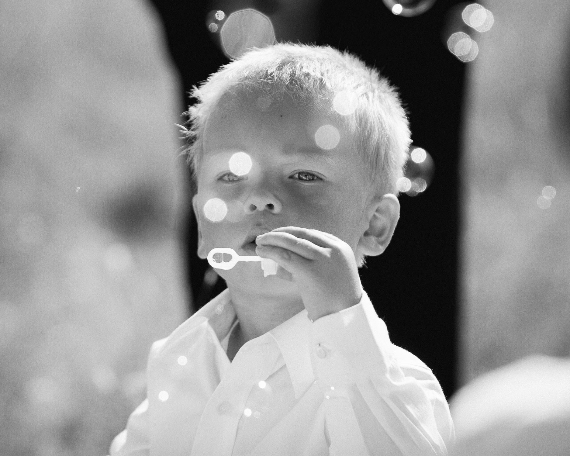 Portrait photo of a small boy blowing bubbles
