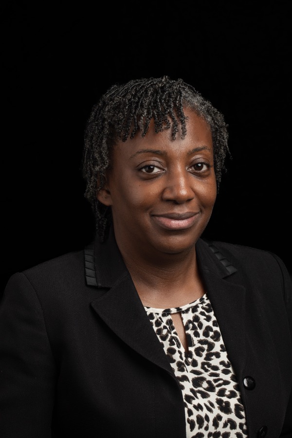 A woman is wearing a black jacket and a leopard print shirt.