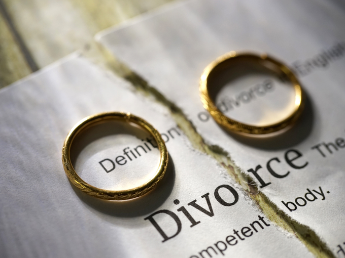 Two gold wedding rings on torn paper with the word 