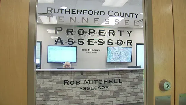 The Rutherford County, Tennessee Property Assessor's office. Signage and two computer screens visible behind a reception desk.