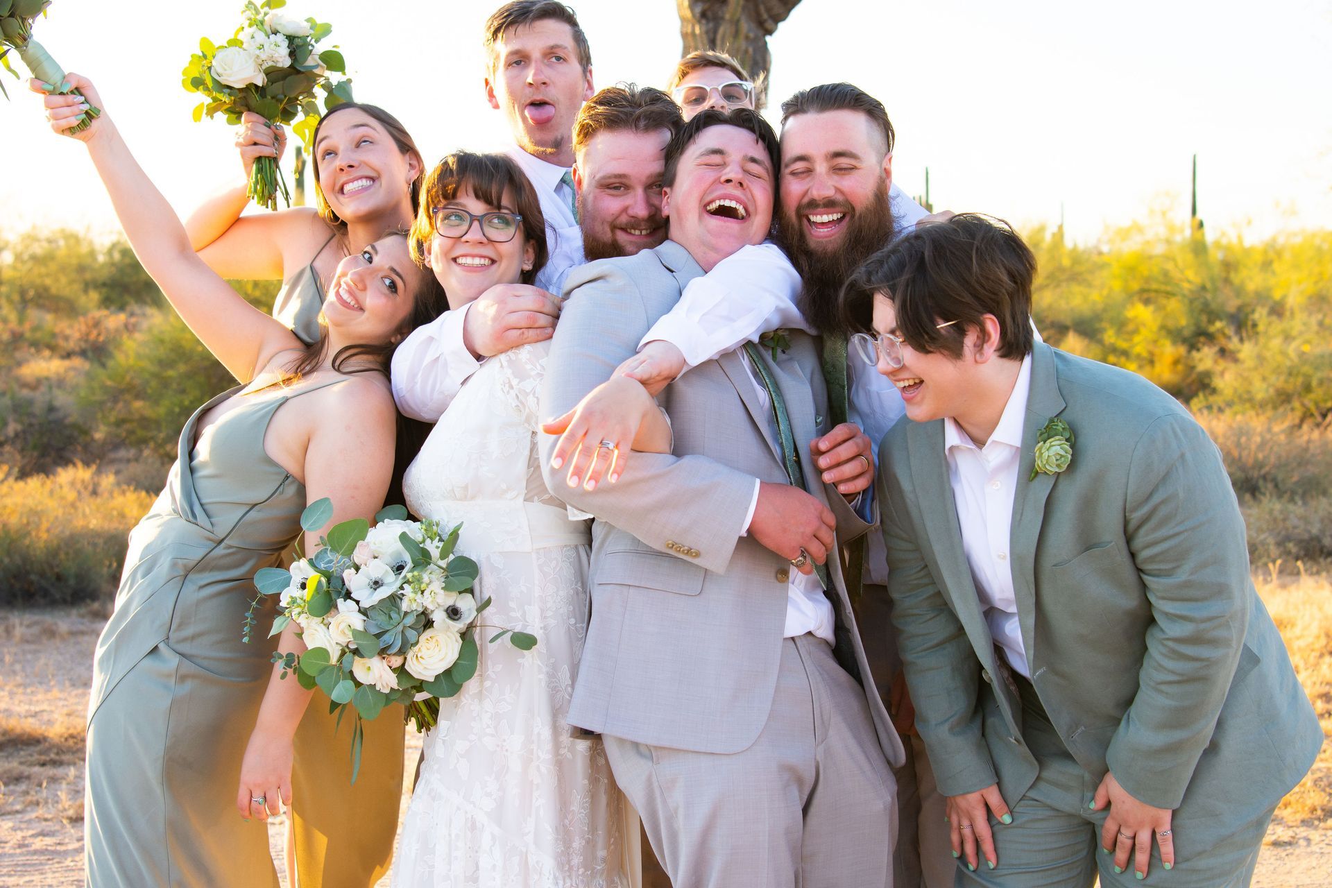 A bride and groom are posing for a picture with their wedding party.