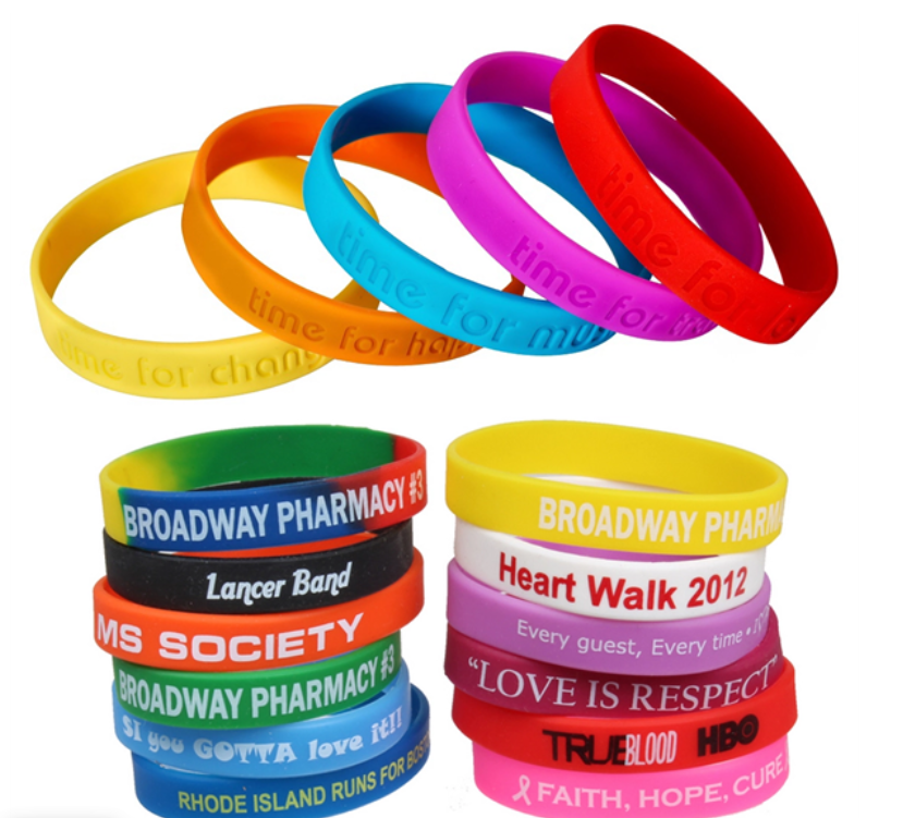 Colorful rubber wristbands stacked and arranged, with various text inscriptions.
