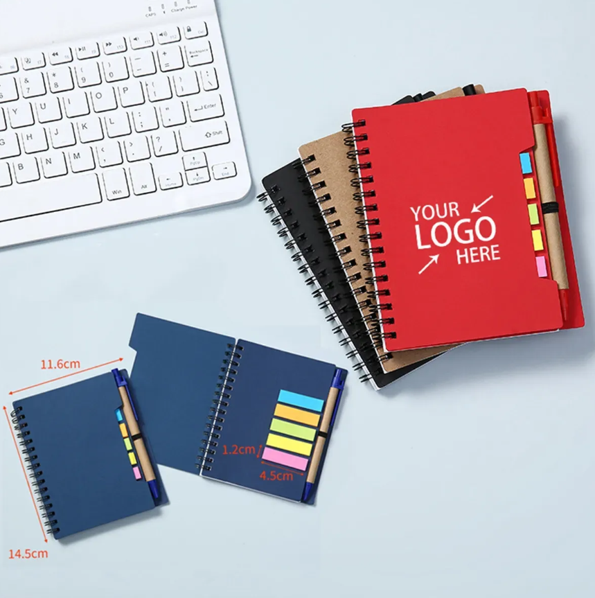 Notebooks with a pen, and a keyboard. One is open.