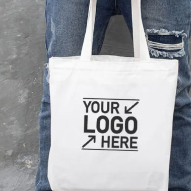 Person holding a white tote bag with 