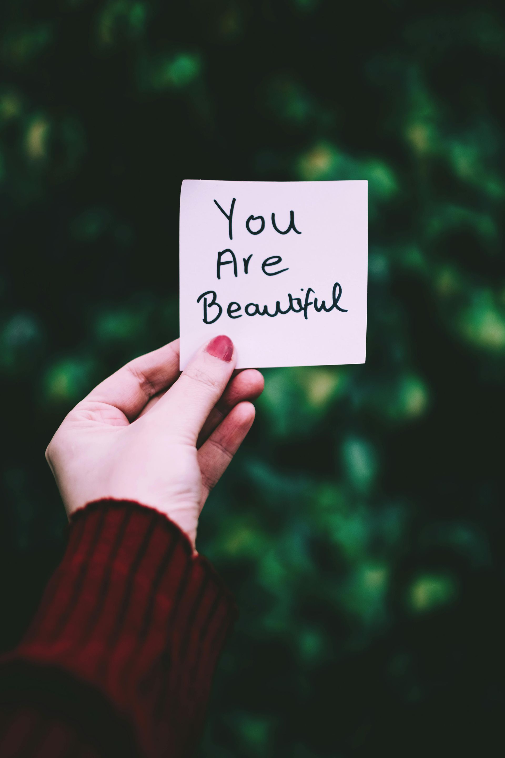 Hand holding a sticky note with 