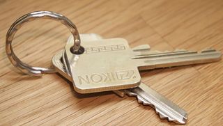 Keys on a ring, with a Nikon key visible. Lying on a wooden surface.