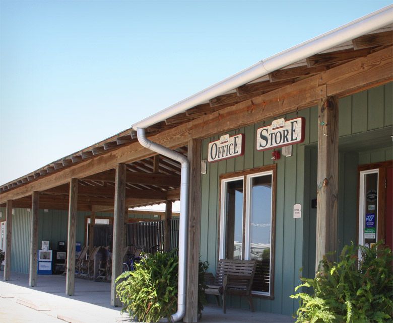 Office and Store front with weathered wood, green siding, and a covered porch.