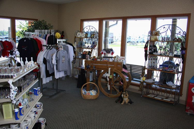 Gift shop interior with merchandise displays, large windows, and an antique wagon.