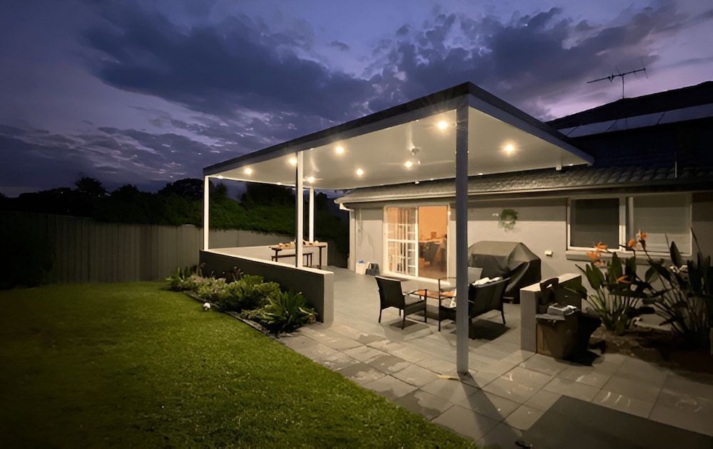 The Backyard Of A House With A Covered Patio At Night — Hunter Home Services in Thornton, NSW