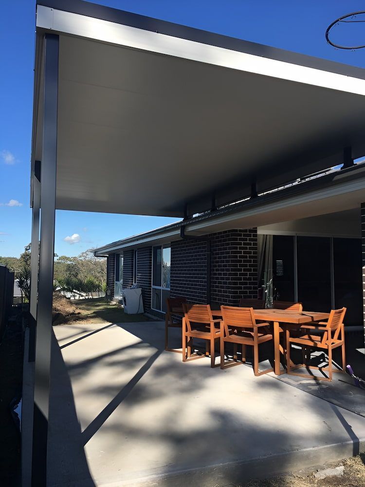 A Patio With A Table And Chairs Under A Canopy — Hunter Home Services in Cessnock, NSW