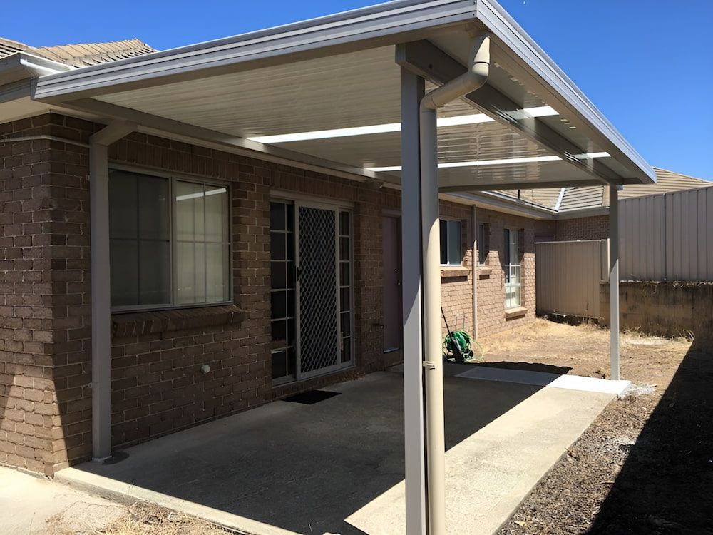 A Brick House With A Covered Patio In Front Of It — Hunter Home Services in Rutherford, NSW
