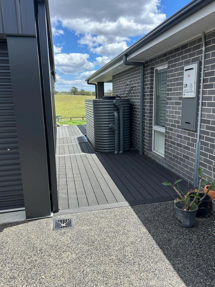 A Brick House With A Deck And A Water Tank On The Side Of It — Hunter Home Services in Thornton, NSW