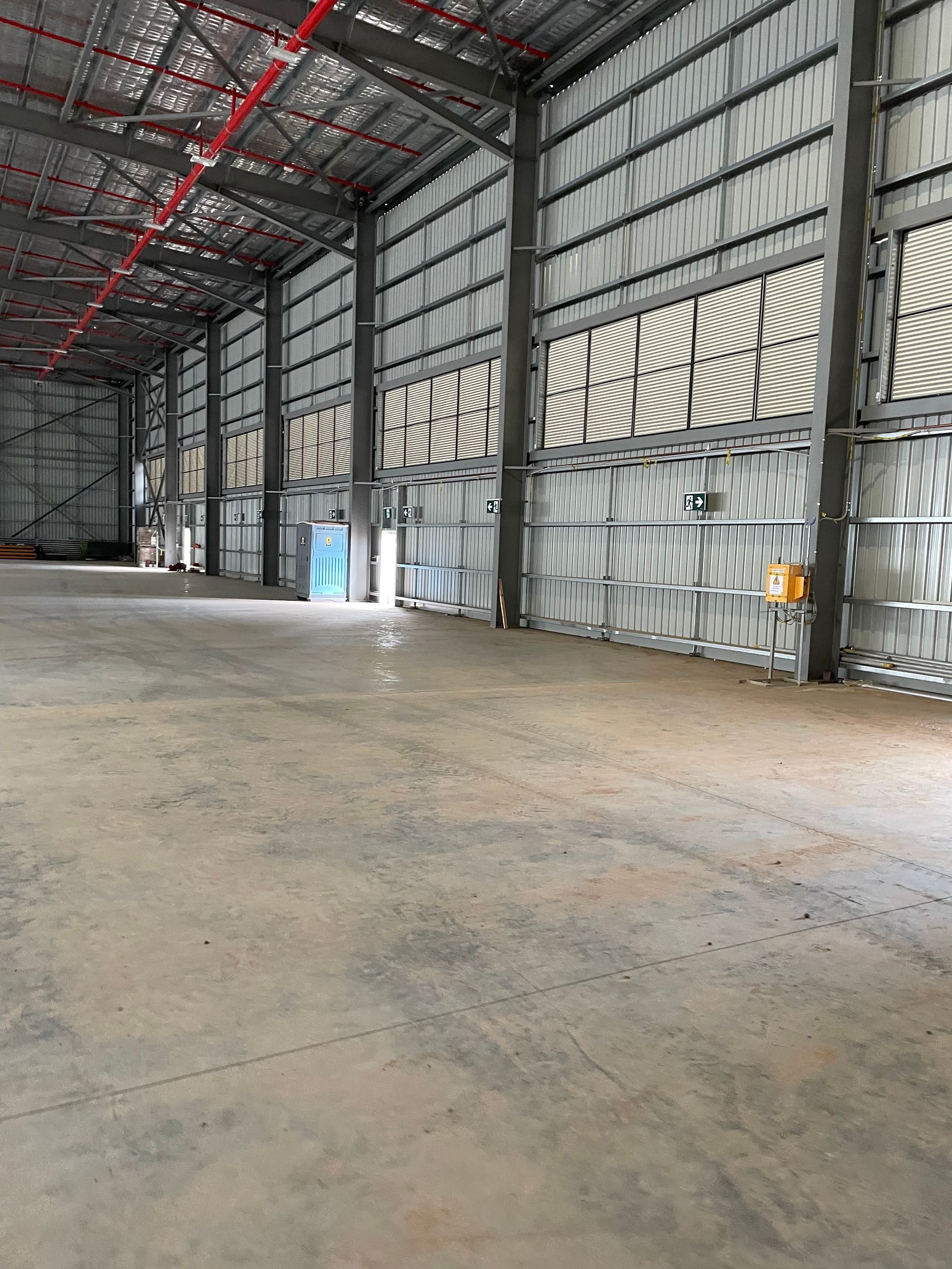 A Large Empty Warehouse with A Lot of Windows and A Concrete Floor — Leisure Coast Powder Coaters in Unanderra, NSW