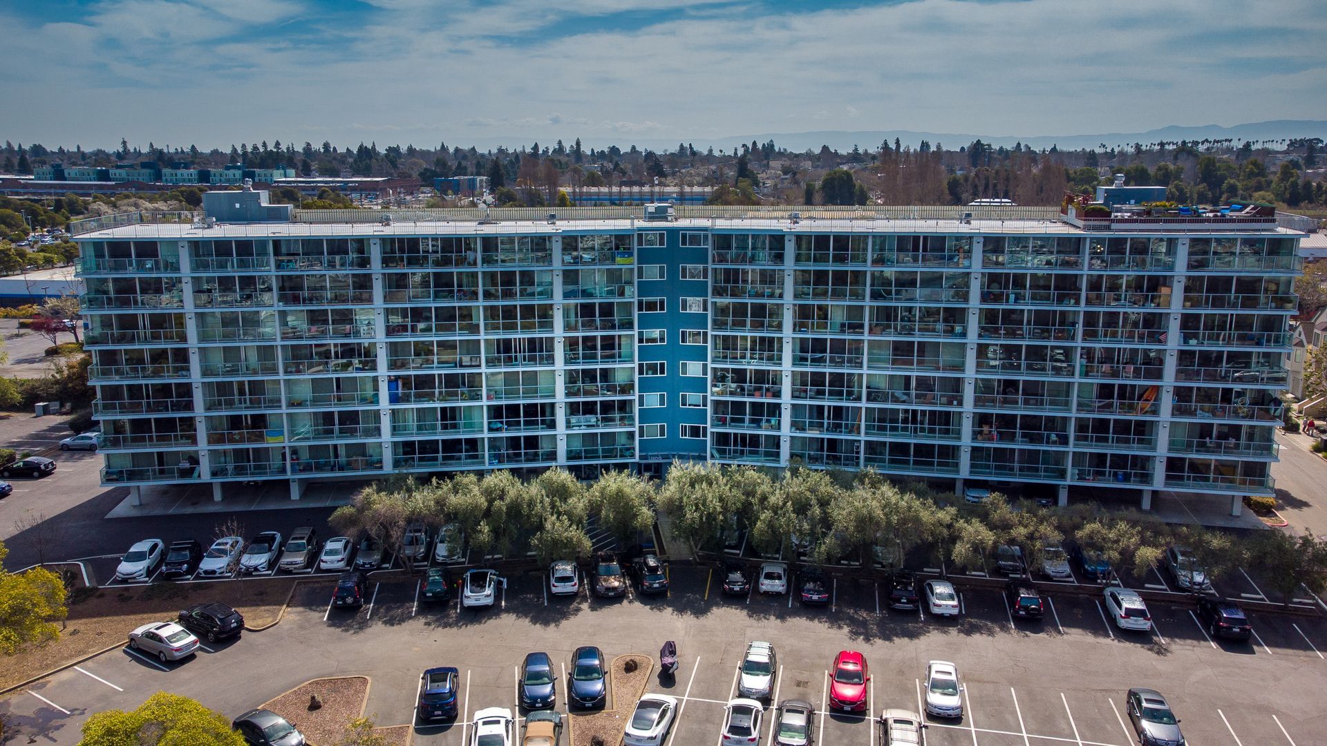 An aerial view of a large building with cars parked in front of it.