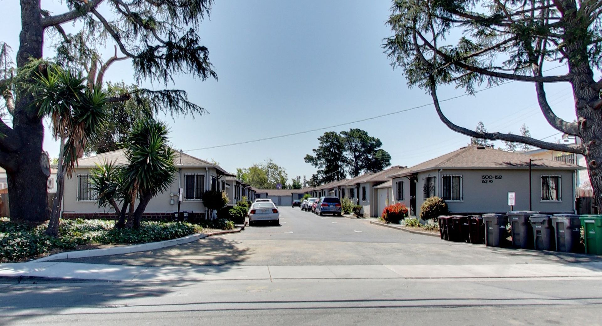 A row of houses with cars parked in front of them