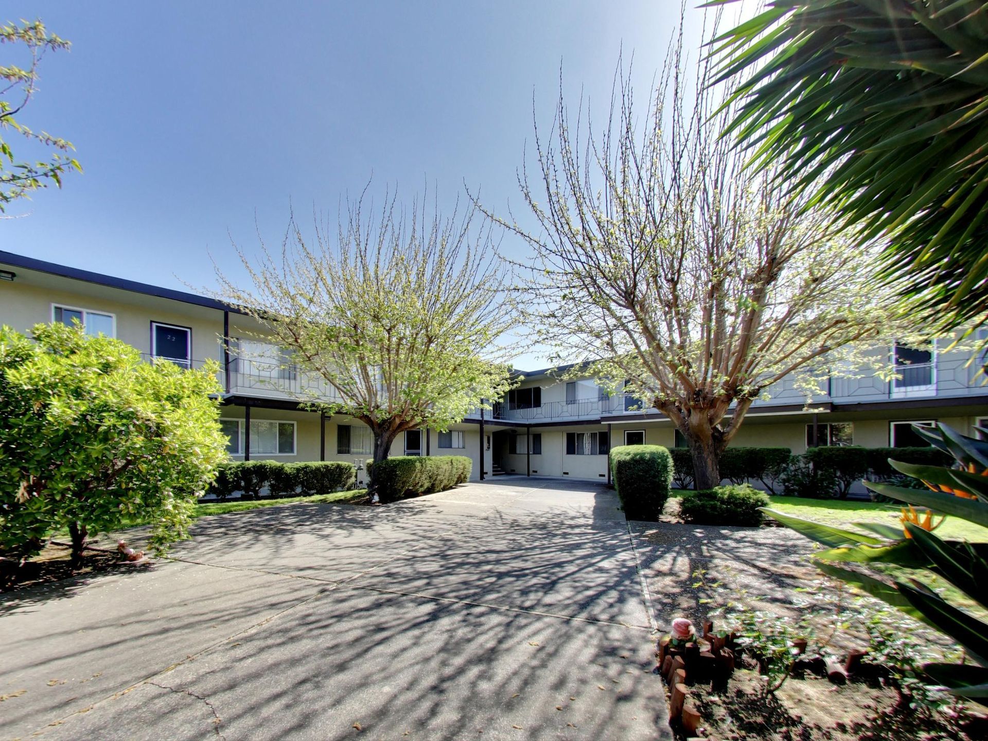 A large apartment building with a lot of trees in front of it