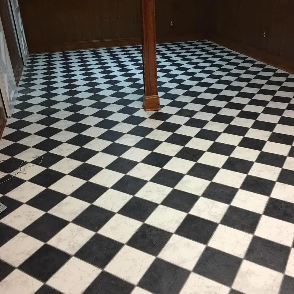 Black and white checkered floor in a room with dark brown walls. A wooden support beam is centered.
