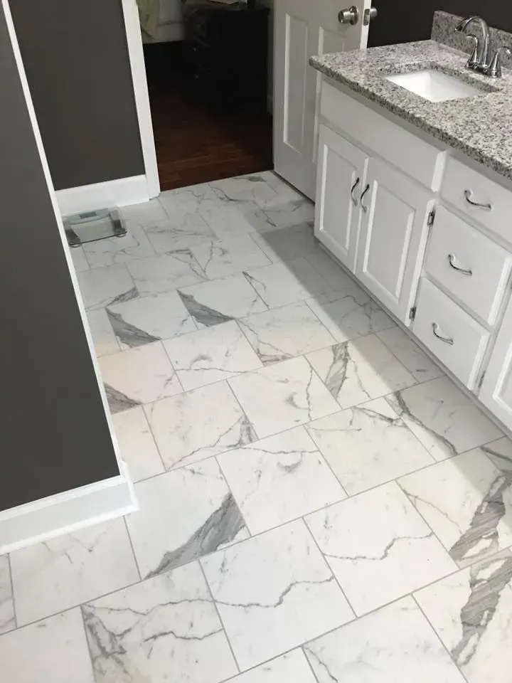 Bathroom with white marble-look tile flooring, a white vanity with a gray granite countertop, and dark gray walls.