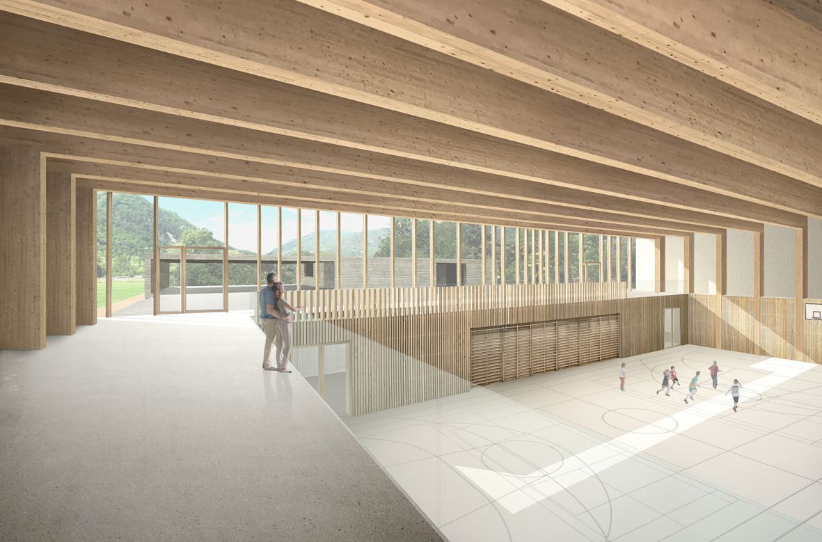 Vista interna di una palestra in legno con ampie finestre. Persone su un balcone e giocatori sottostanti.