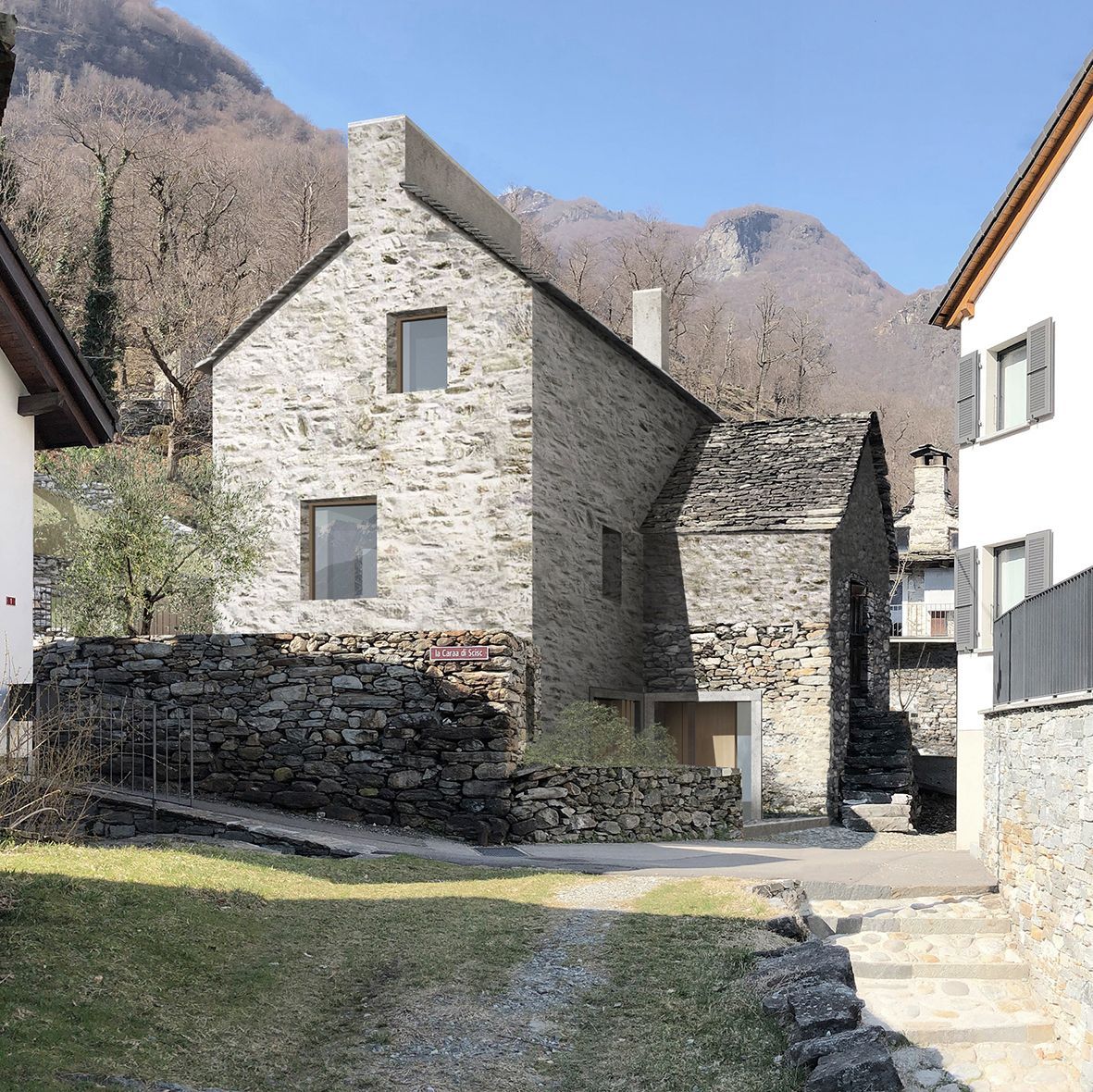 Casa in pietra in un villaggio di montagna, caratterizzata da una stradina acciottolata e da edifici circostanti.