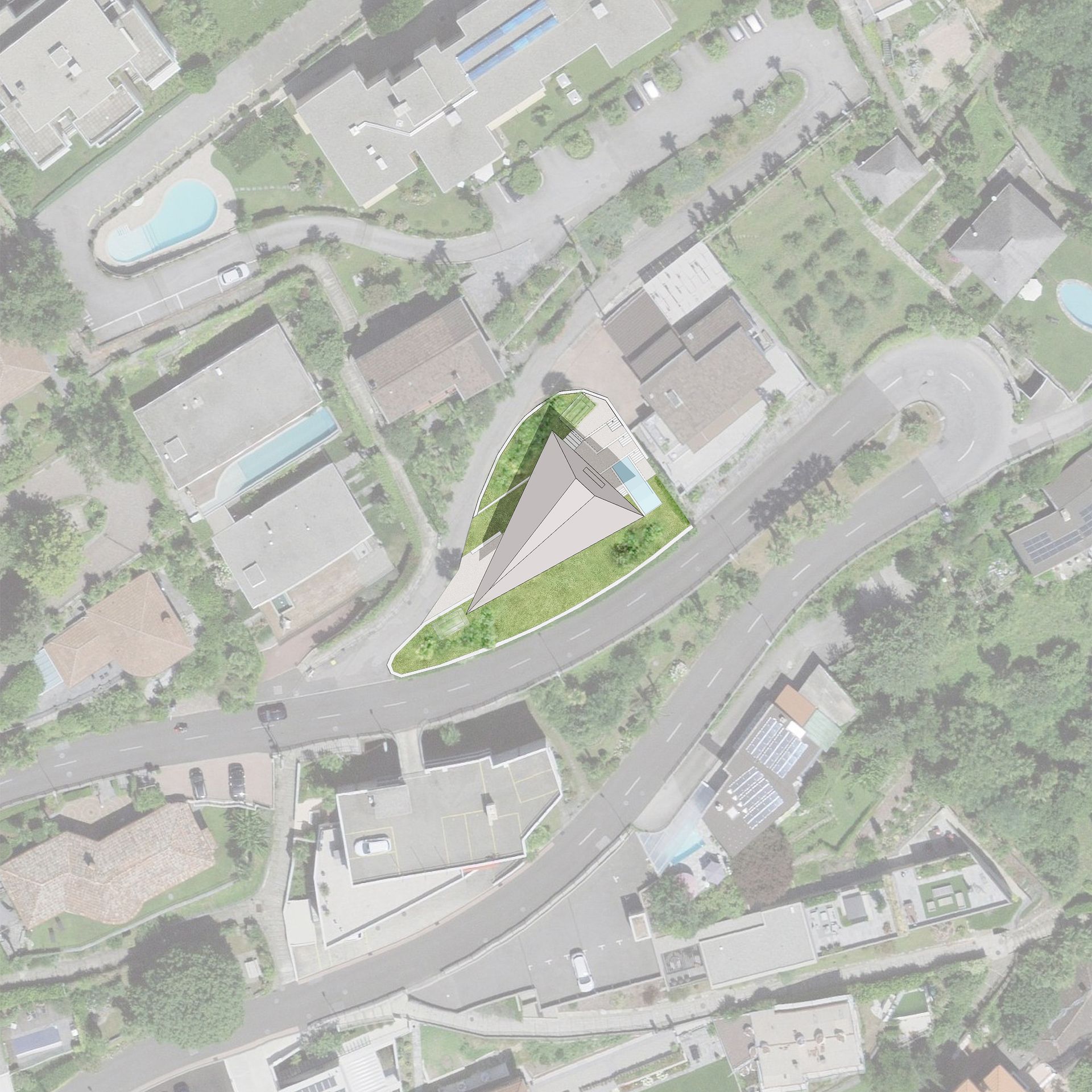 Vista aerea di un edificio con un prato triangolare, circondato da strade, edifici e alberi.