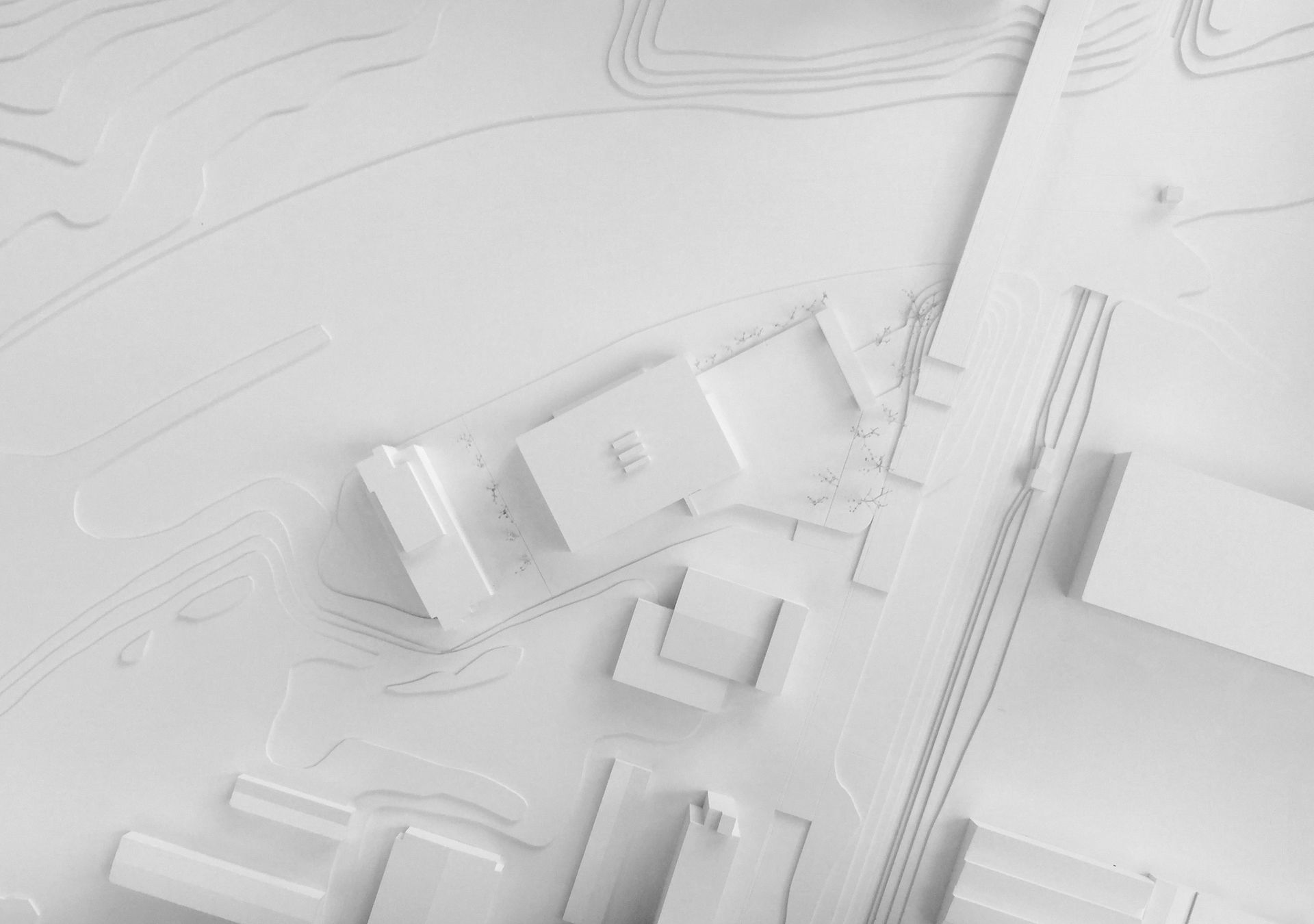 Modello architettonico: strutture bianche su una base sagomata, che rappresentano una planimetria con edifici e strade.