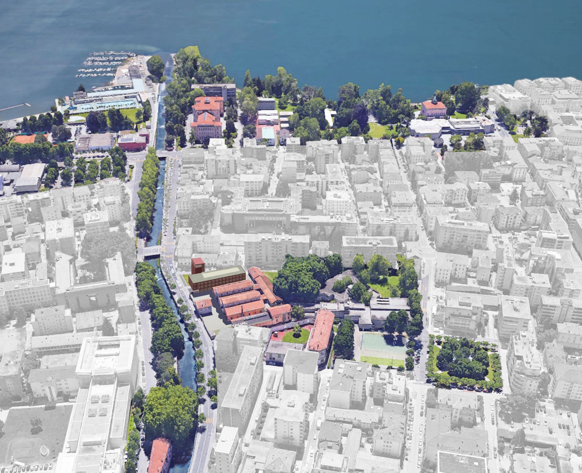 Vista aerea di una città che costeggia un lago. Edifici e alberi, con un'area evidenziata di edifici con tetti rossi.