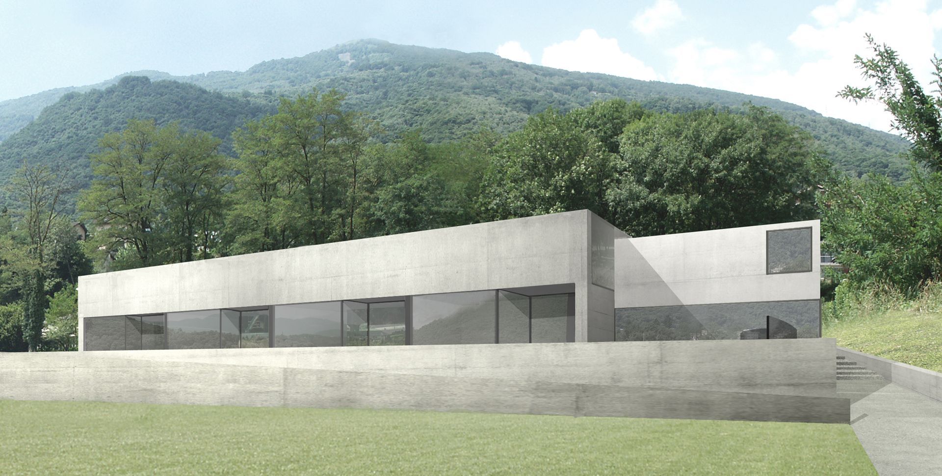 Moderno edificio in cemento con ampie finestre, incastonato in uno scenario montuoso e boscoso.