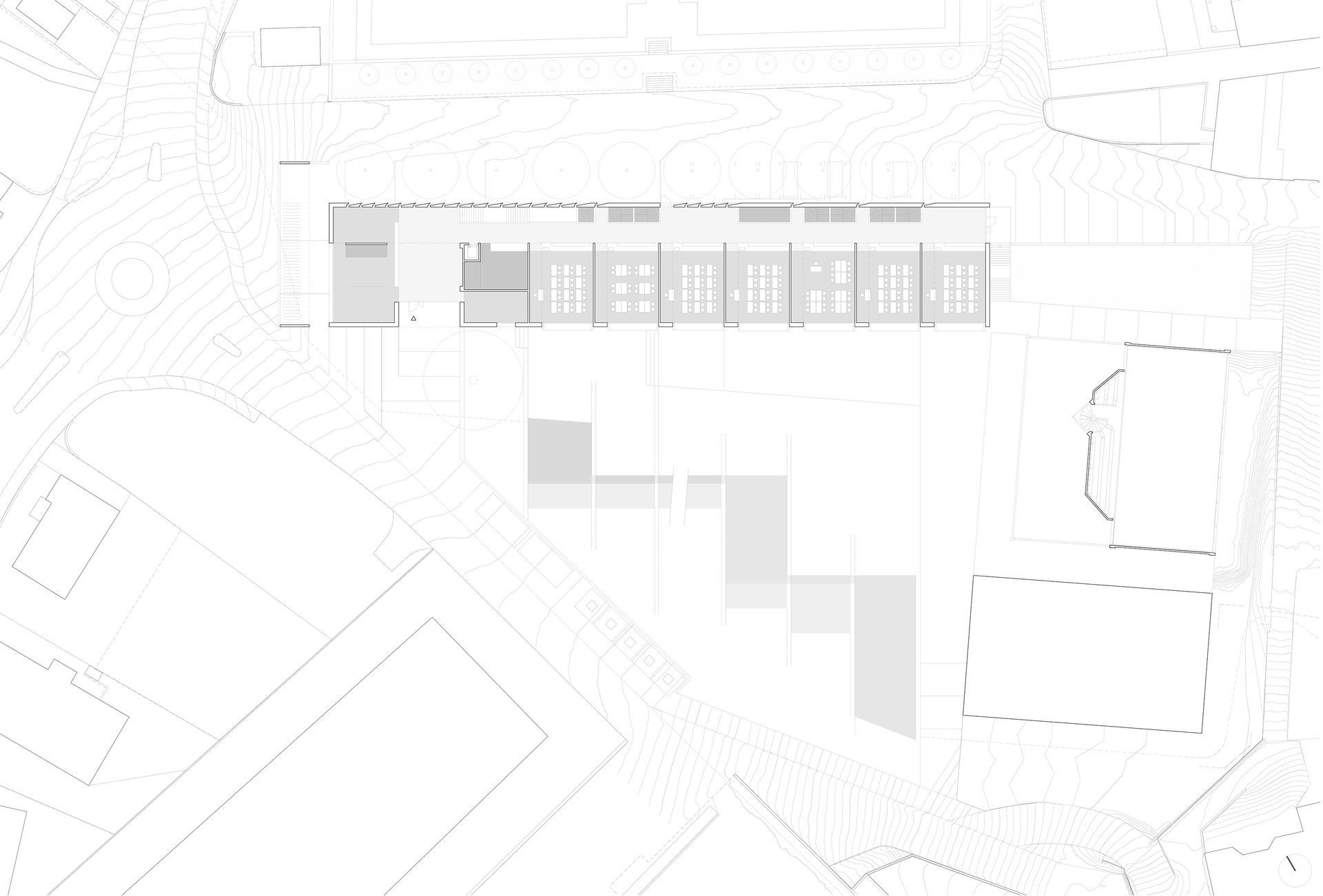 Vista in pianta architettonica: edificio rettangolare lungo con strutture di collegamento, grigio chiaro su sfondo bianco.