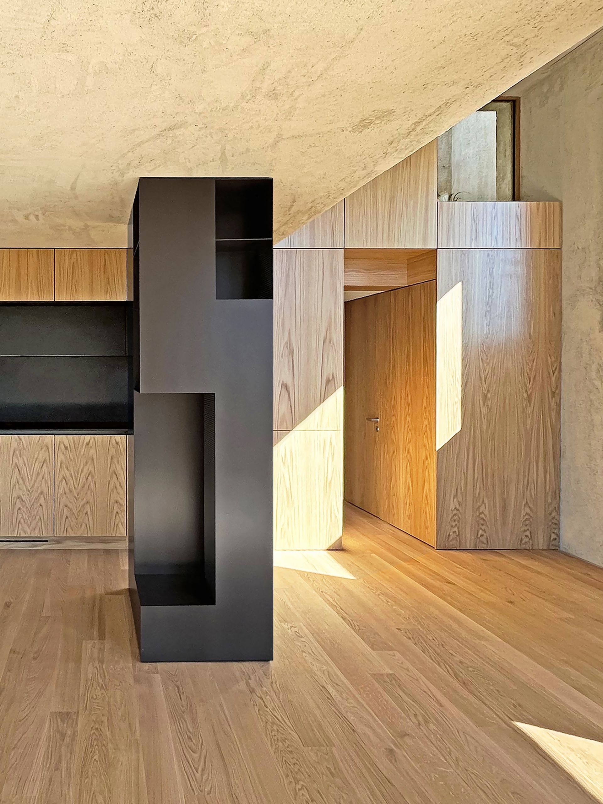 Interni moderni con mobile contenitore in ferro grigio, pavimenti in legno e soffitto in cemento. Locale illuminato dal sole.