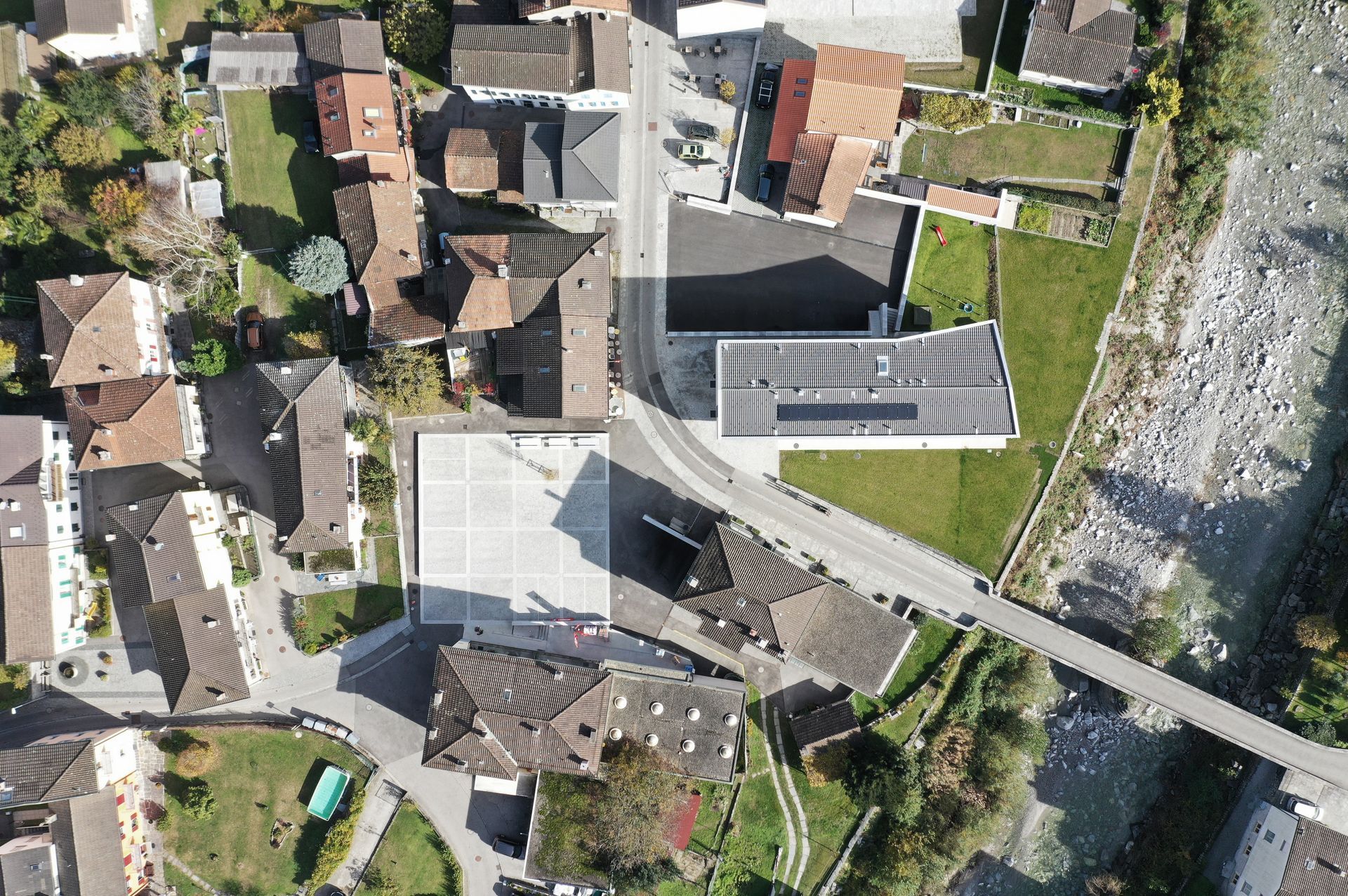 Vista dall'alto di un villaggio europeo con edifici in pietra, strade e un fiume.