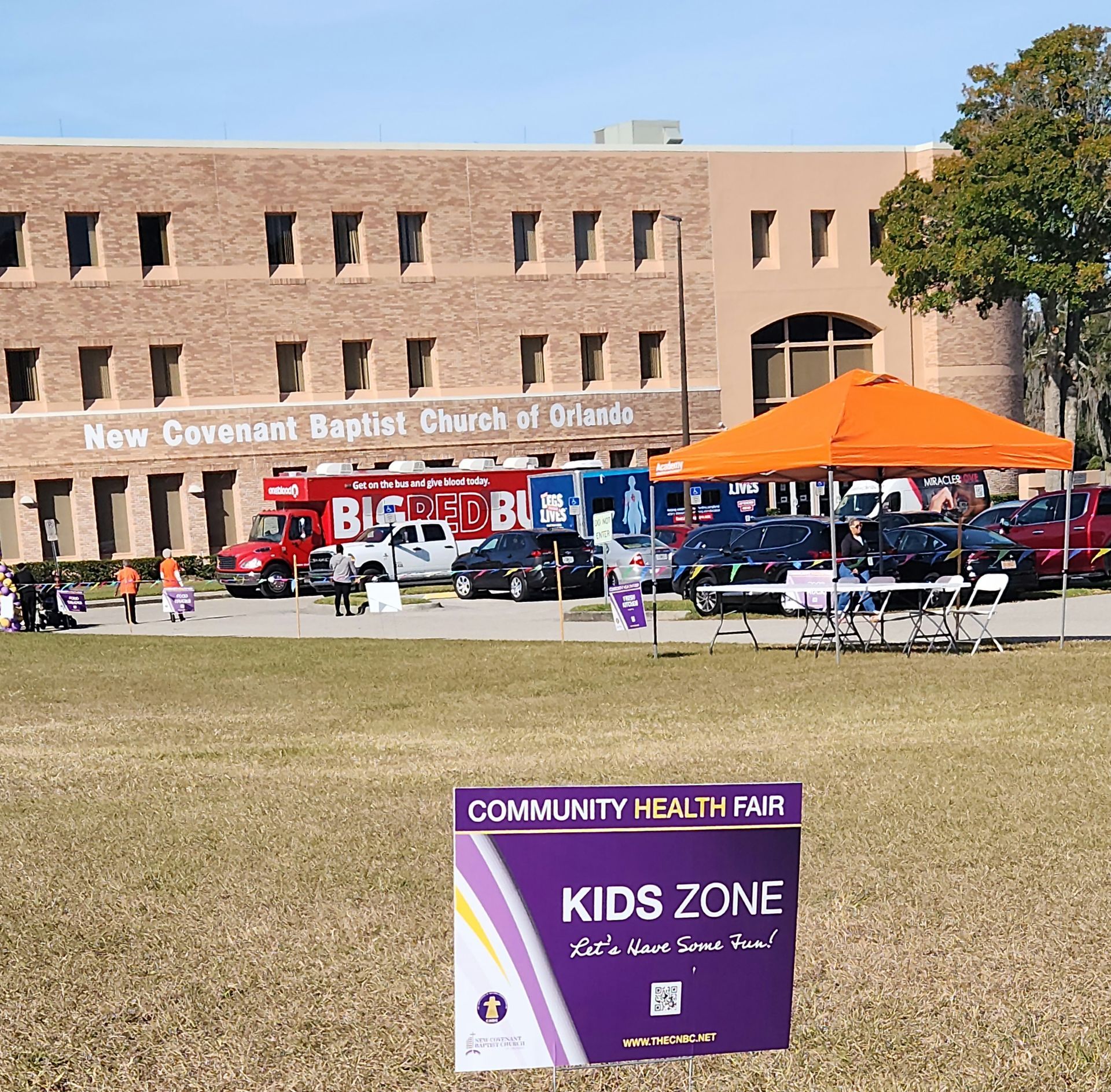Community health fair at New Covenant Baptist Church. A "Kids Zone" sign is in the foreground.