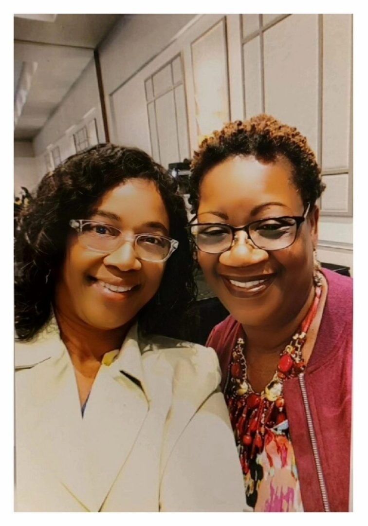 Two women smiling, posing for selfie.