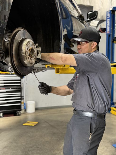 Technician working on brake system | Redhawk Auto Service