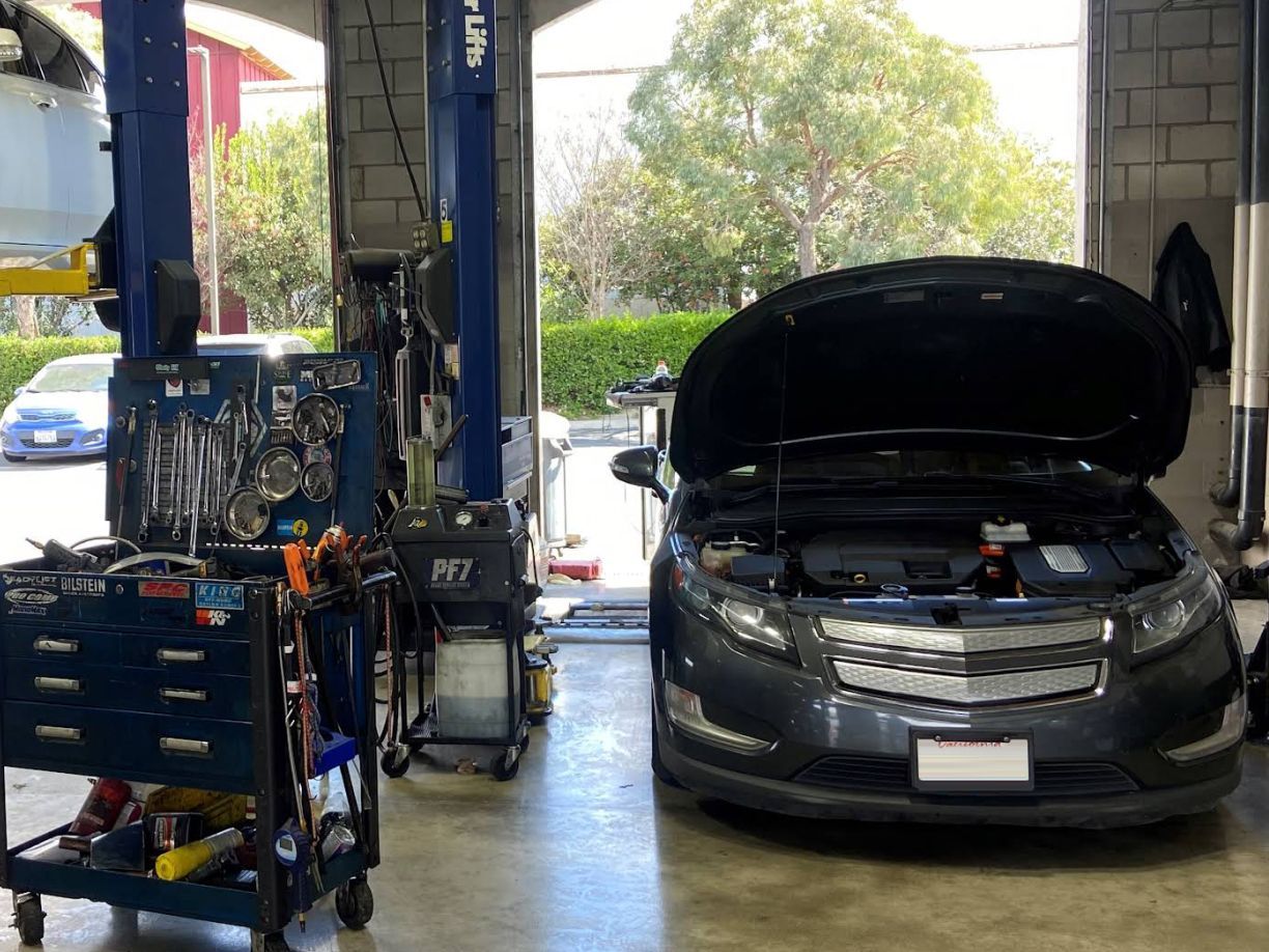 Car with hood up in garage | Redhawk Auto Service