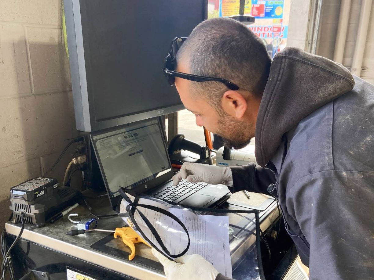 Man looking at computer on desk in garage | Redhawk Auto Service