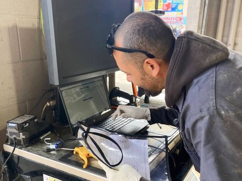 Man looking at computer on desk in garage | Redhawk Auto Service
