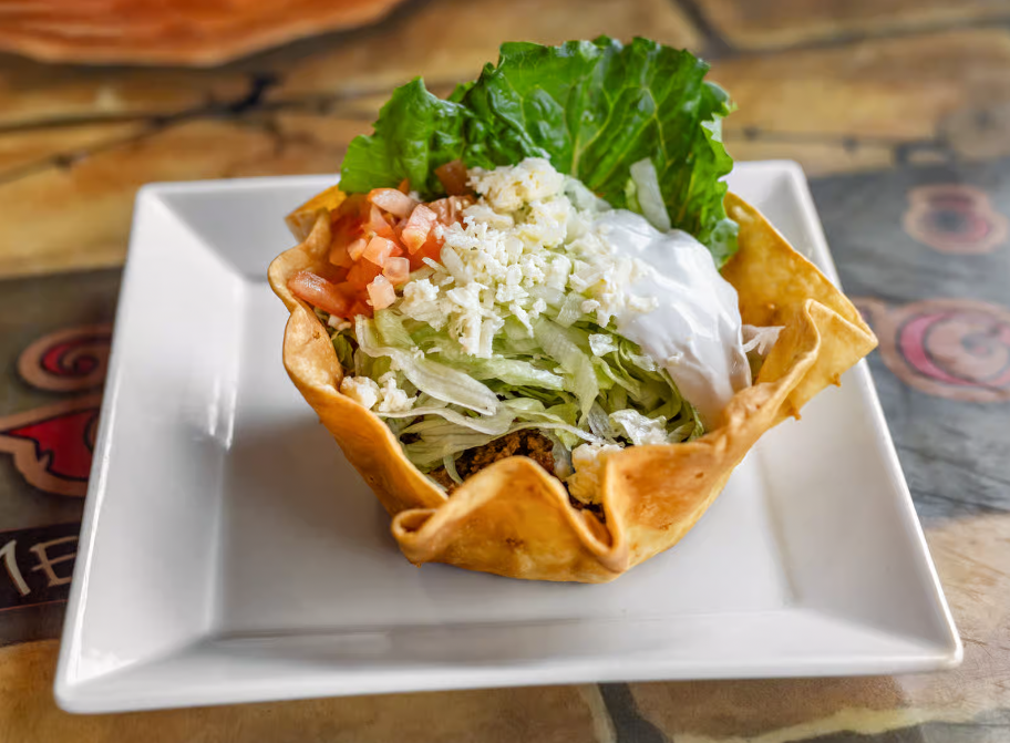 A bunch of meat is cooking on a grill.