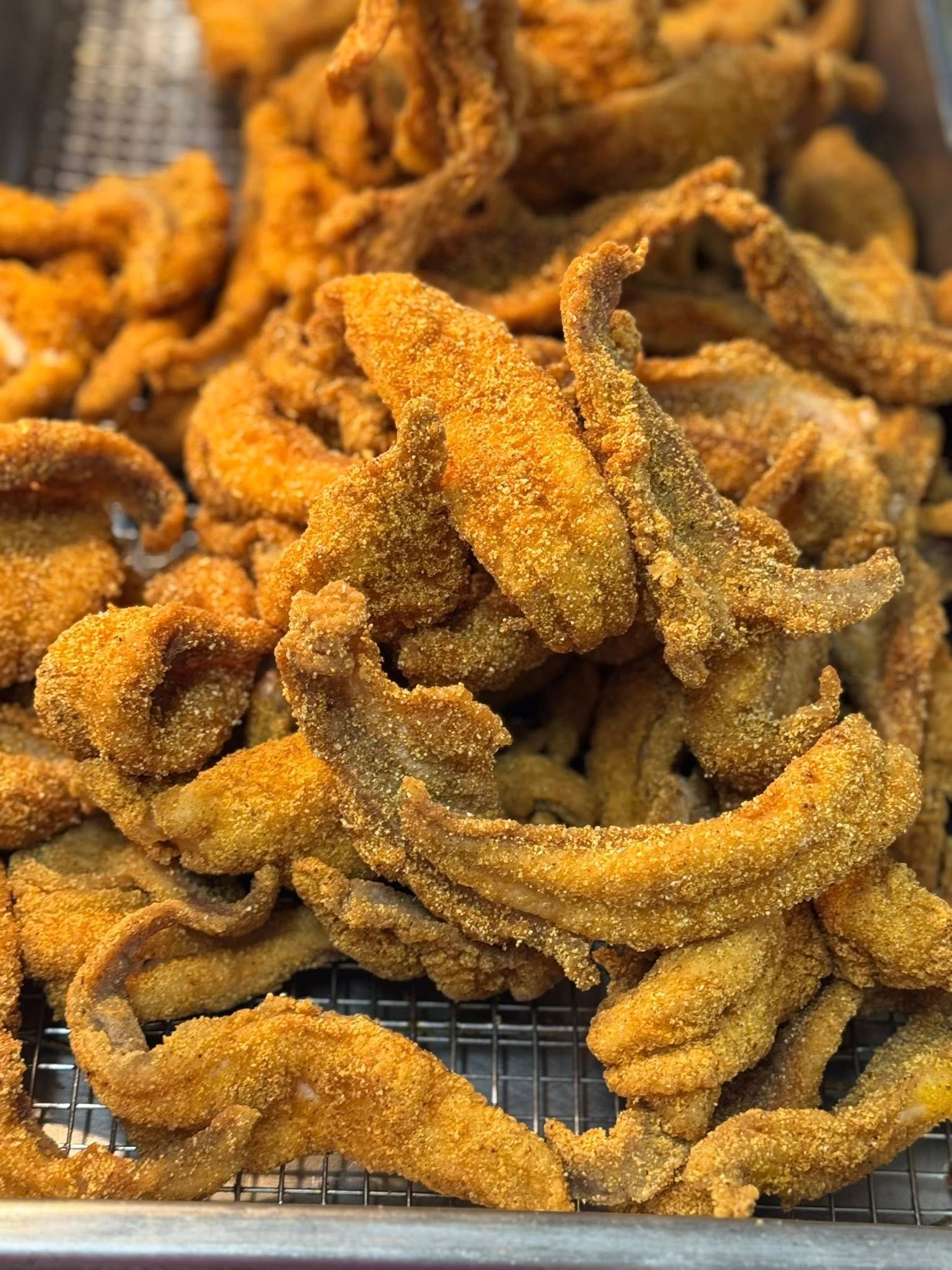 A plate of food with french fries , shrimp , fish , and dips on a table.