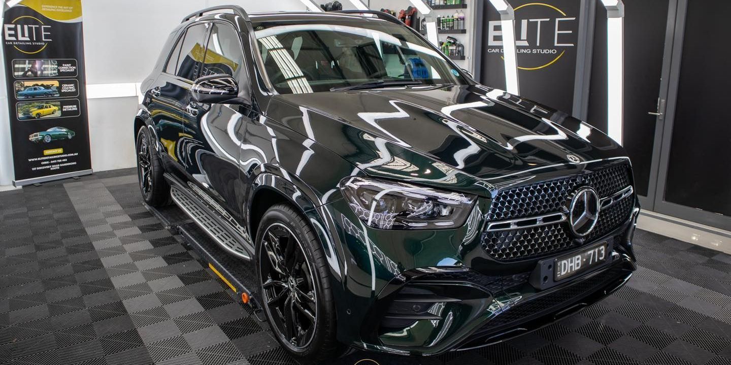 Ceramic Coating - A black Porsche Cayenne GTS is parked in front of a house