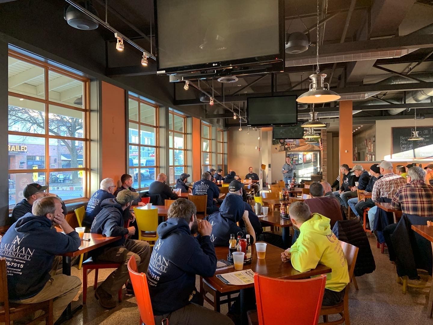 The Nauman Inc. team sitting at tables in a restaurant.