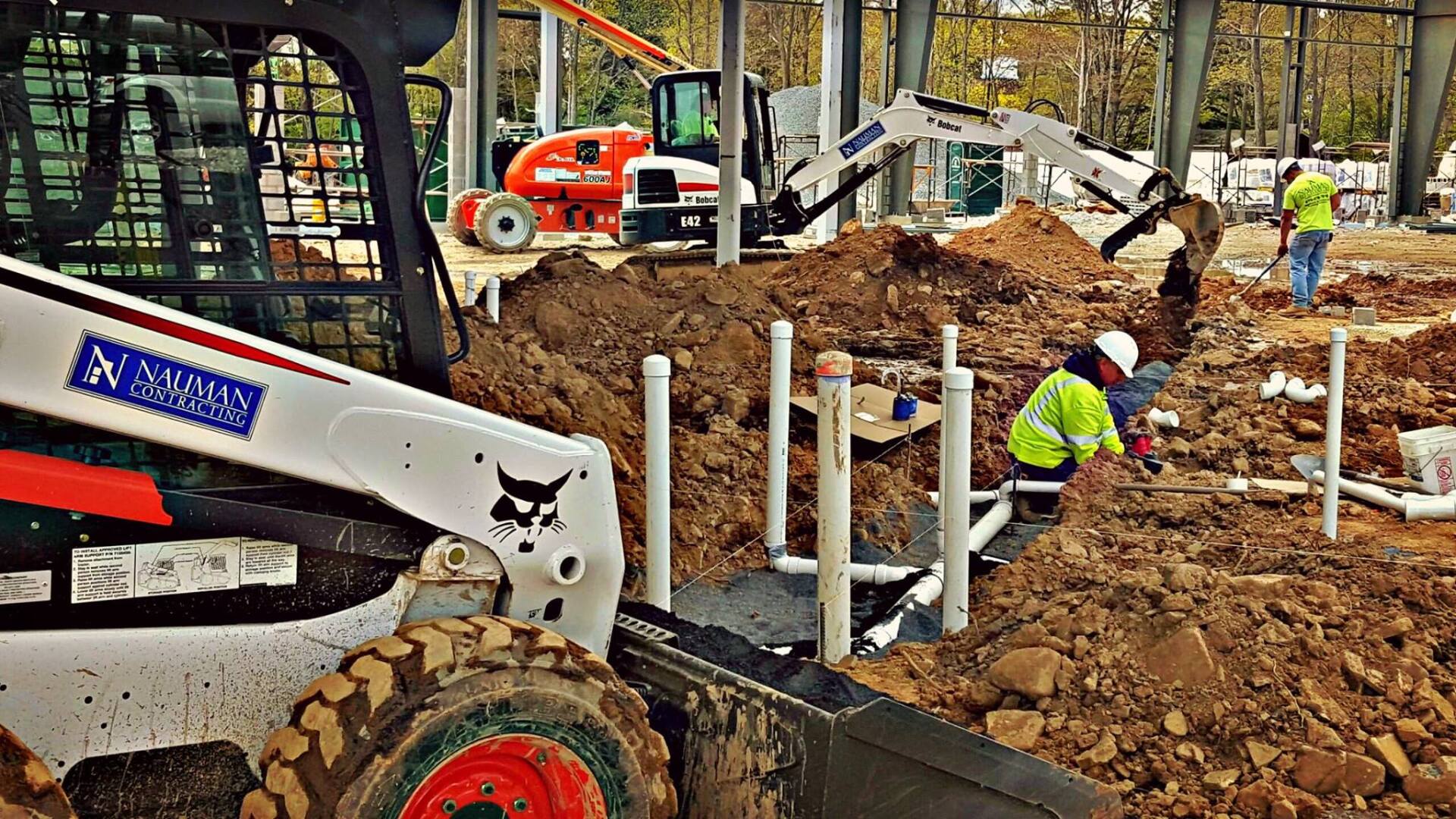 A group of Nauman inc. construction workers are working on a construction site.